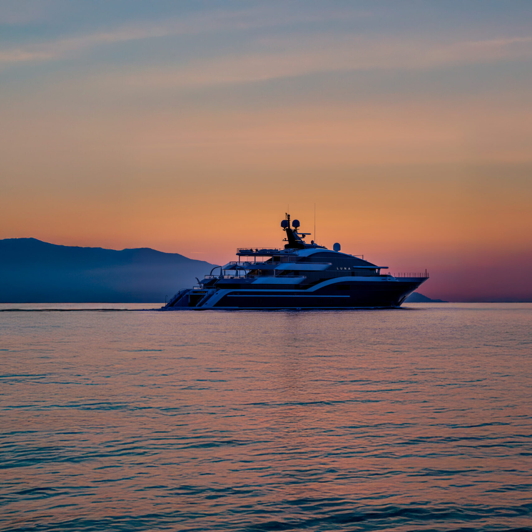 Luna at sea at sunset, hills on the horizon